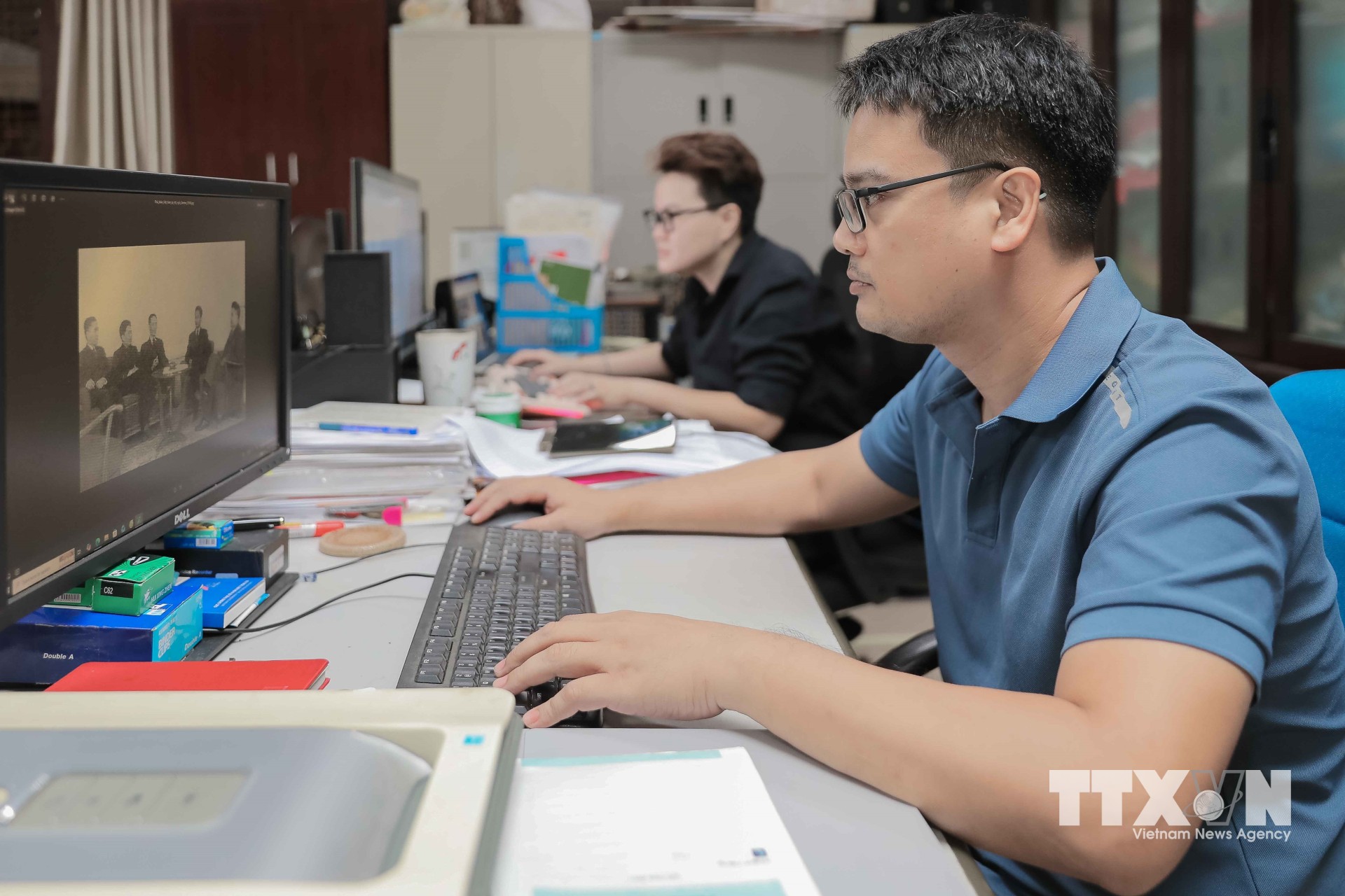 Cán bộ bảo tàng thực hiện công tác chuyển đổi số, biên tập và xử lý các tư liệu ảnh lịch sử quý giá trên máy tính để đưa vào hệ thống trưng bày và lưu trữ số. (Ảnh: Phan Phương/TTXVN)